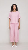 Woman wearing a pink outfit on a plain background