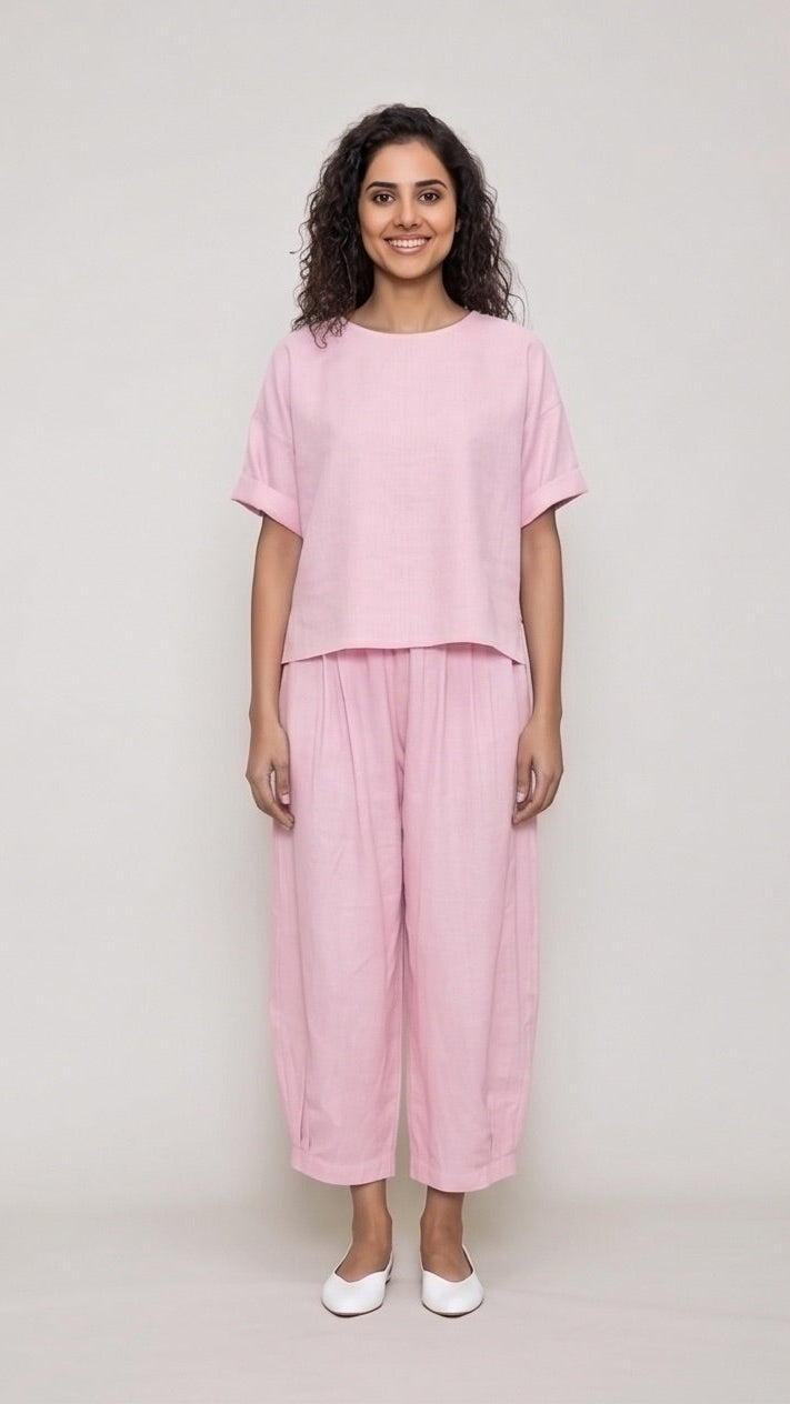 Woman wearing a pink outfit on a plain background