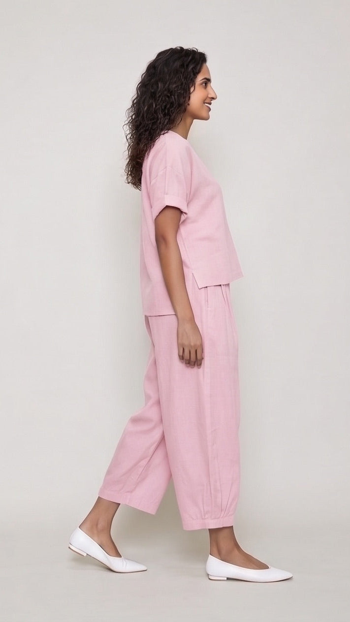 Woman wearing a pink outfit on a plain background