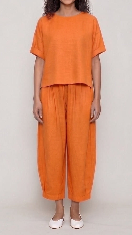 Woman wearing an orange outfit on a plain background