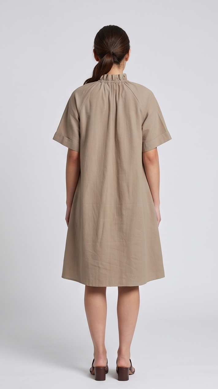 Woman wearing a beige dress from behind on a white background