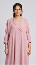 Woman wearing a pink dress against a plain background