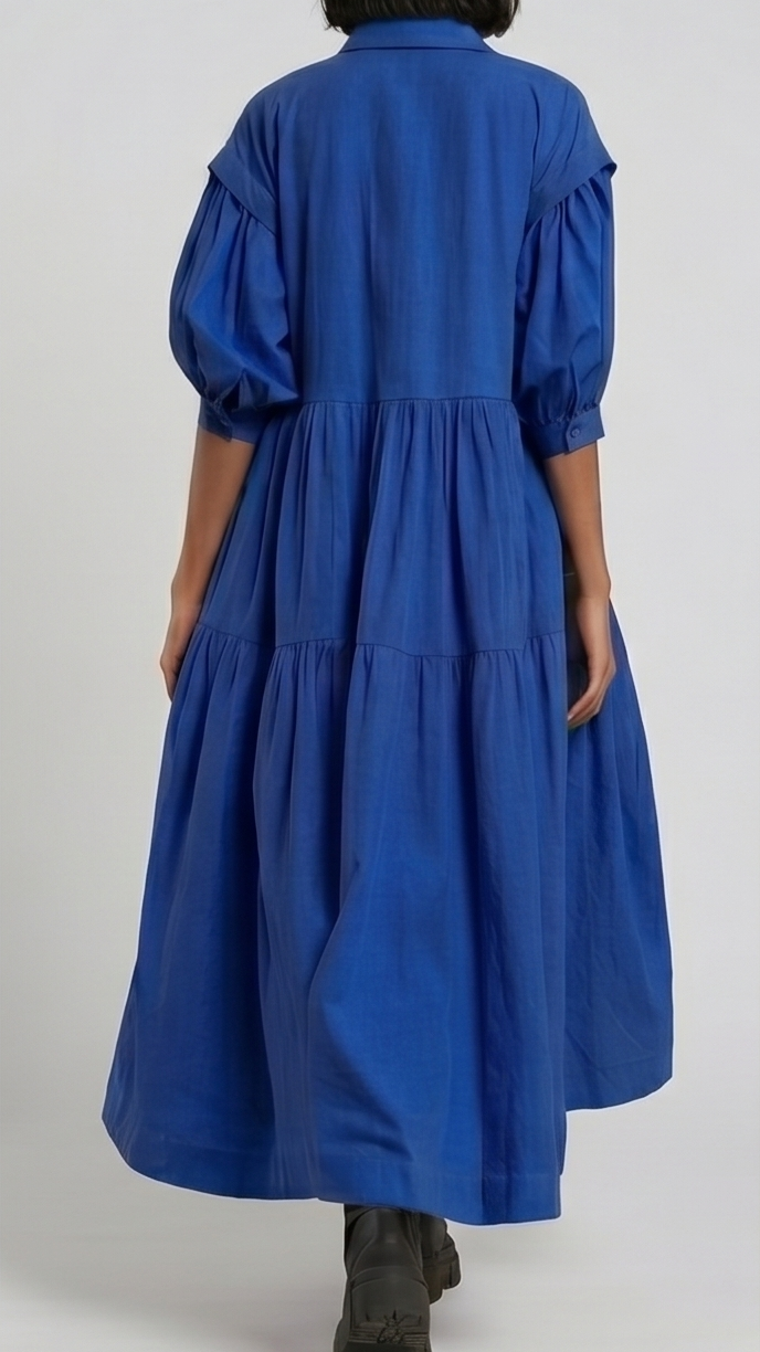 Person wearing a blue dress with puffed sleeves on a white background