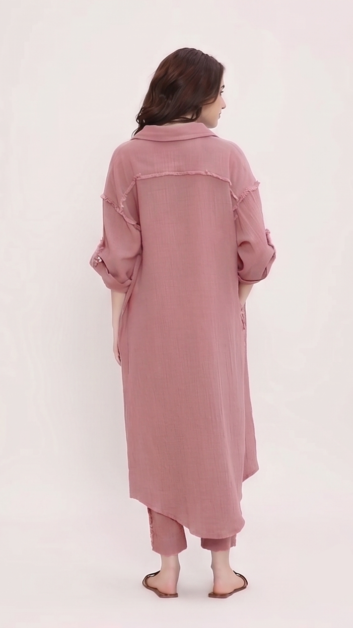 Person wearing a long pink dress on a white background