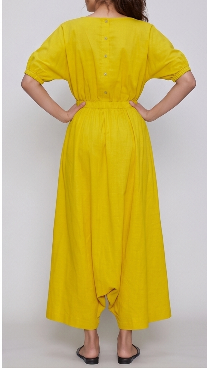 Person wearing a yellow dress with a plaiN background