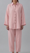Woman wearing a pink pajama set against a gray background