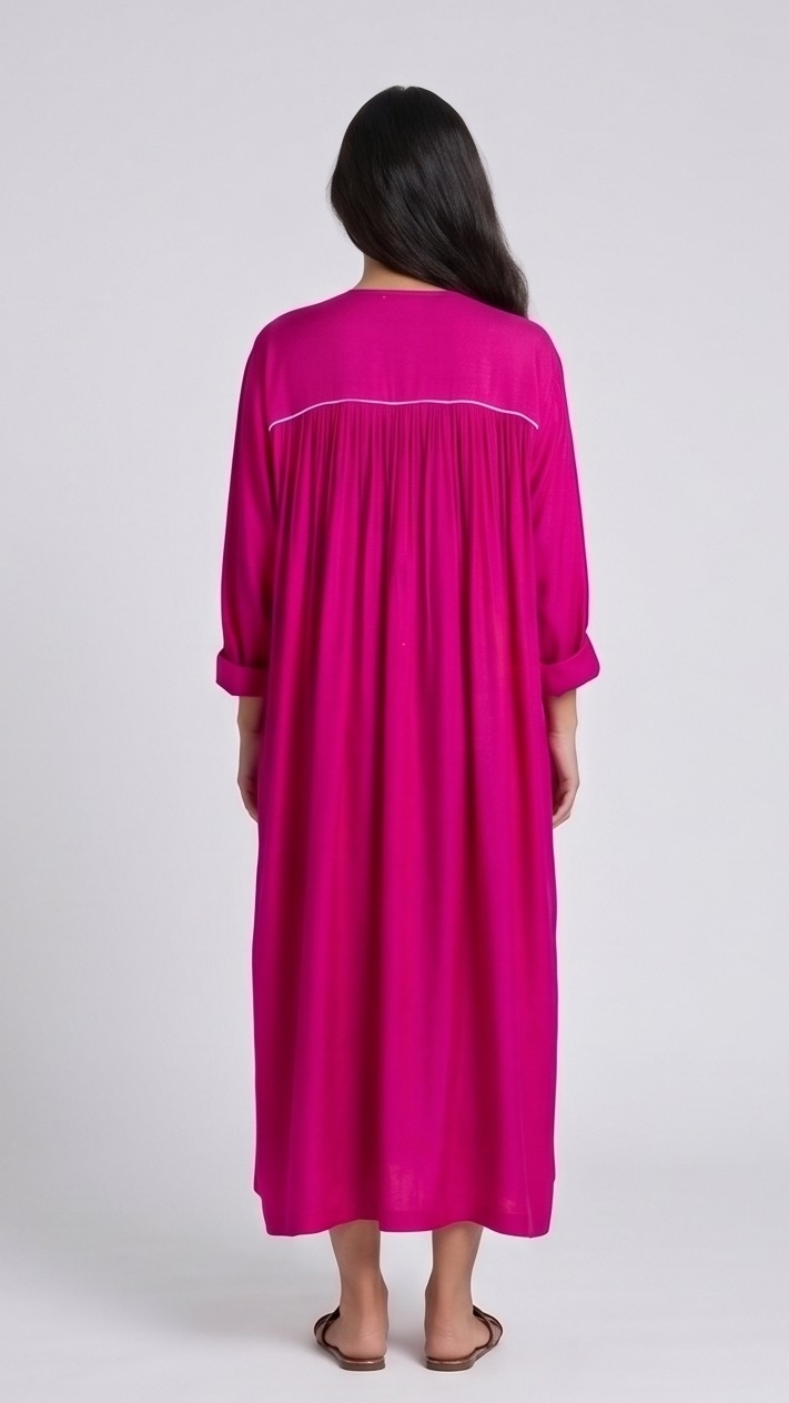 Woman wearing a hot-pink dress with a white trim on a plain background