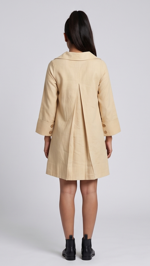 Woman wearing a beige dress on a plain background