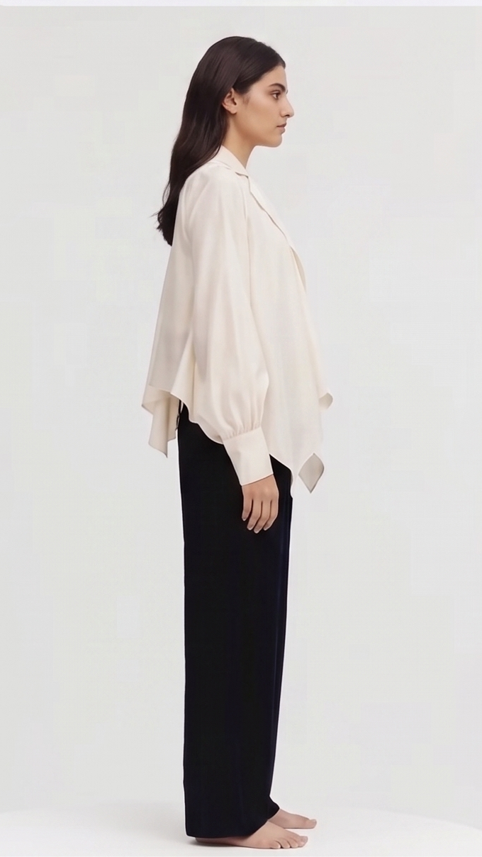 Woman wearing a beige blouse and black pants on a white background
