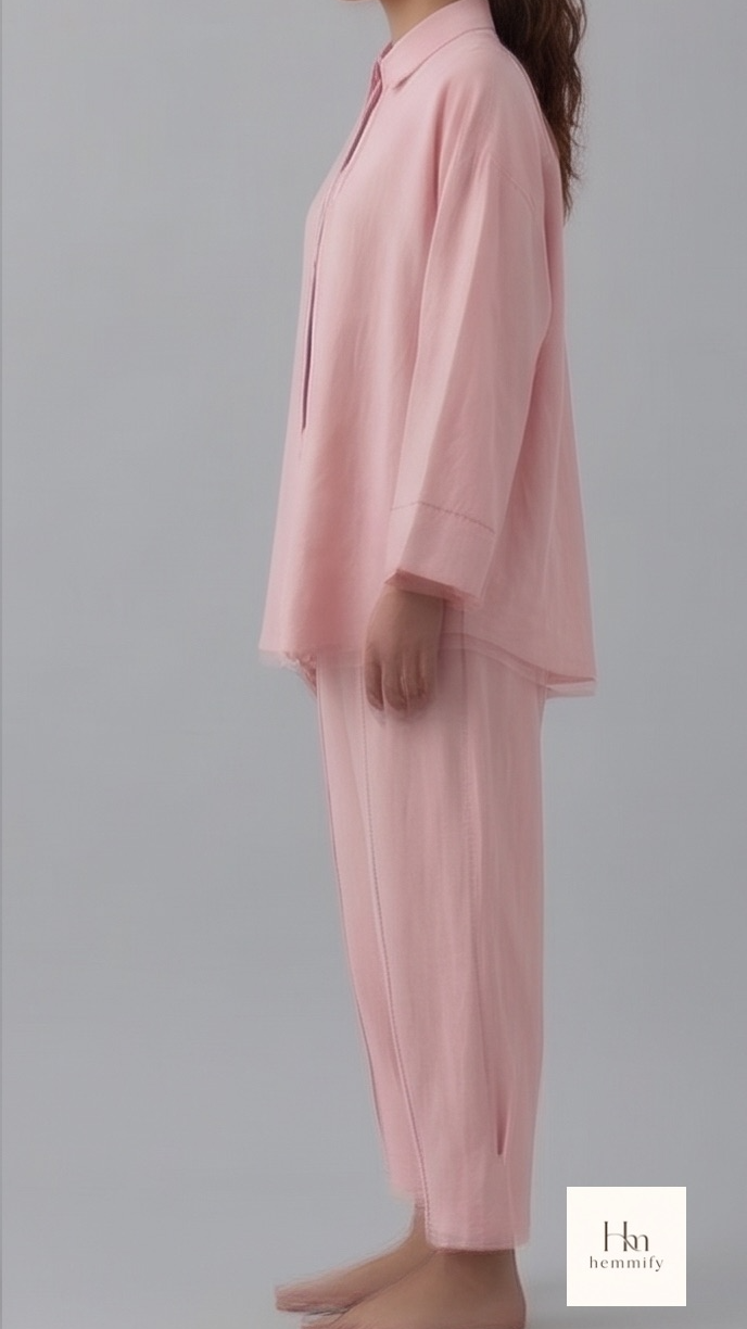 Woman wearing pink pajama set against a gray background