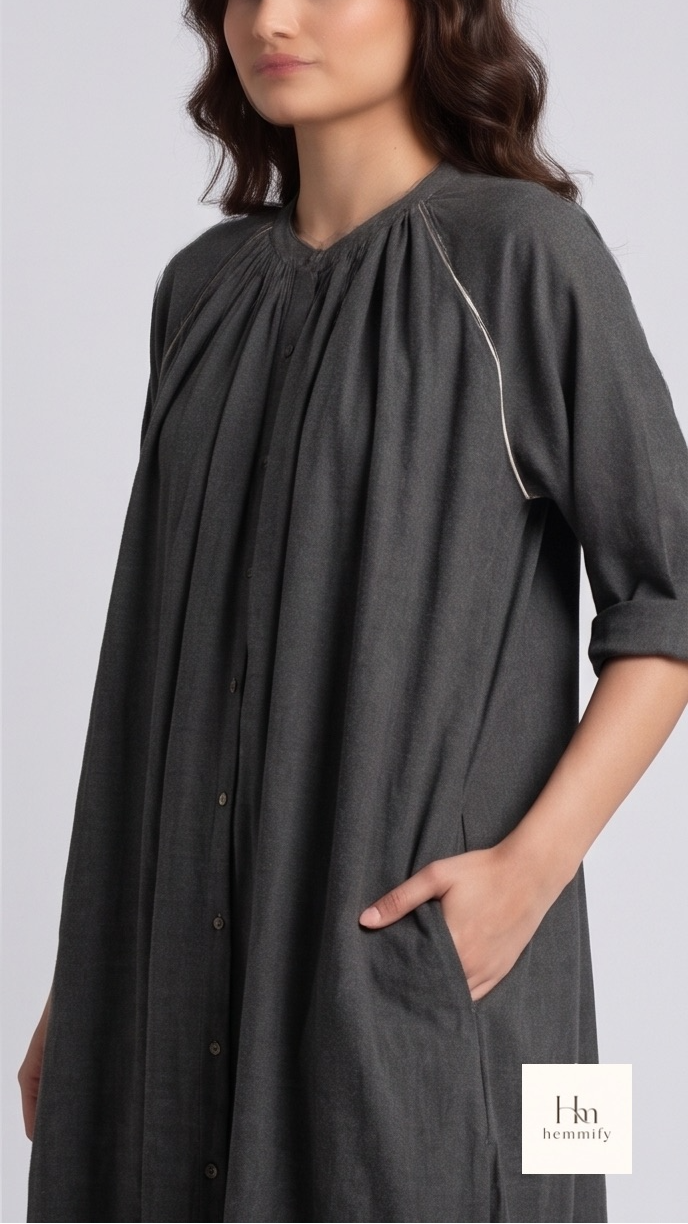 Woman wearing a gray dress with a plain background